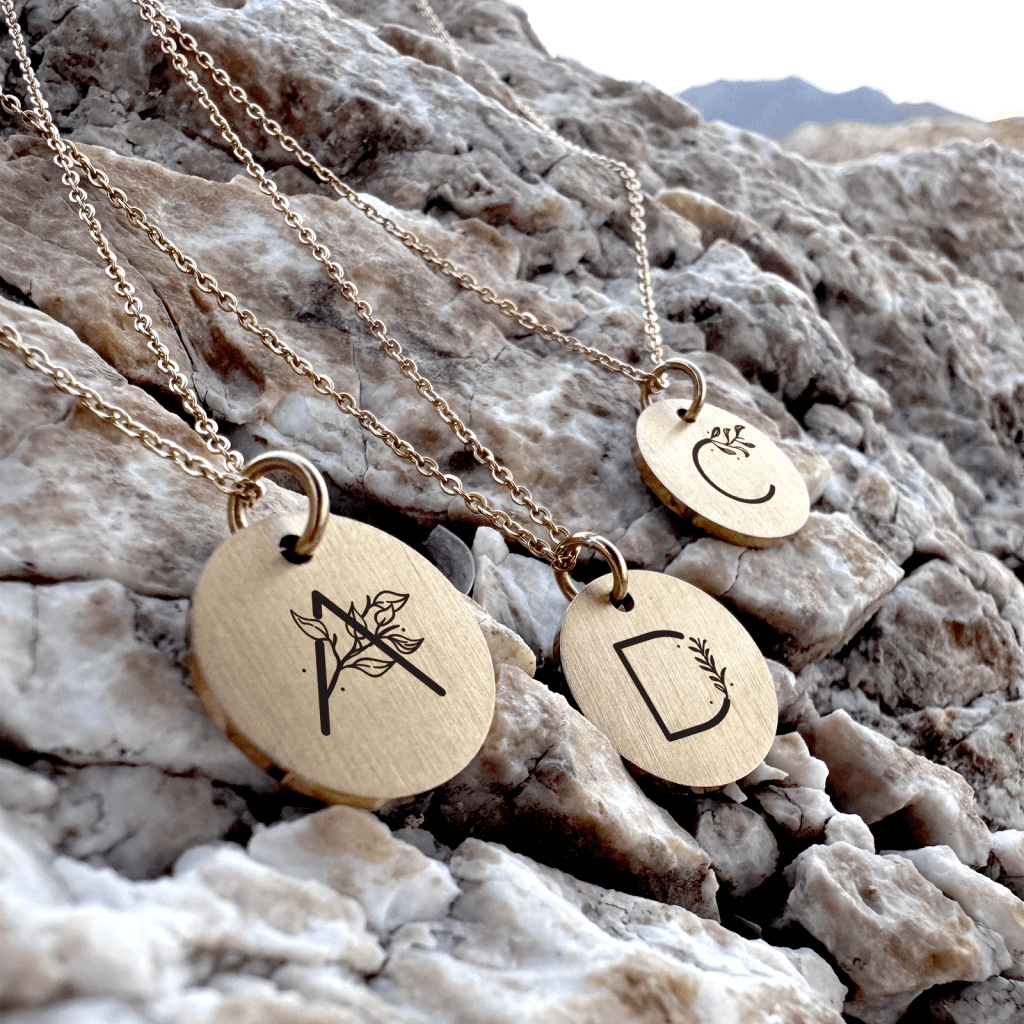 Halskæde med bogstav og blomster på rundt vedhæng - Personligt Smykke fra Øndig Jewellery. Personligt smykke med mindeværdi
